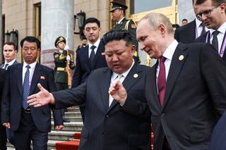 Russia's President Vladimir Putin (R) and North Korea's leader Kim Jong Un (C) leave after their meeting in Beijing